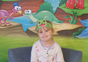 Dzieci pozują na tle dekoracji Dnia Dinozaura