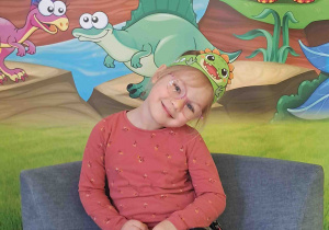 Dzieci pozują na tle dekoracji Dnia Dinozaura