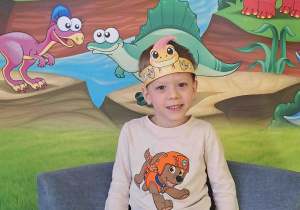 Dzieci pozują na tle dekoracji Dnia Dinozaura