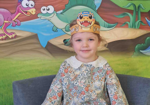 Dzieci pozują na tle dekoracji Dnia Dinozaura