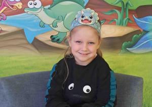 Dzieci pozują na tle dekoracji Dnia Dinozaura