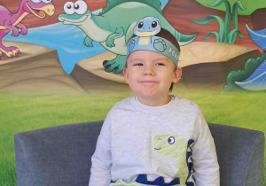 Dzieci pozują na tle dekoracji Dnia Dinozaura