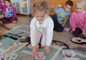 Dzieci uczestniczą w zajęciach dydaktycznych na dywanie, dopasowując obrazki i poznając pojęcia związane z porą dnia