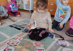 Dzieci uczestniczą w zajęciach dydaktycznych na dywanie, dopasowując obrazki i poznając pojęcia związane z porą dnia