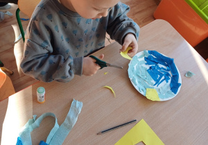 Dzieci wykonują pracę plastyczną, rozwijając kreatywność i sprawność manualną