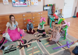 Dzieci prezentują kolorowe balonowe kwiaty wykonane podczas zabaw z animatorką