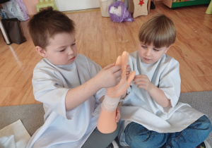 Dzieci uczą się, jak prawidłowo założyć bandaż na rękę