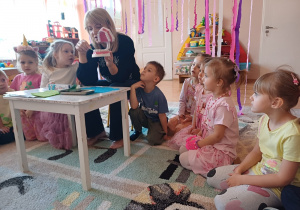 Dzieci z zainteresowaniem obserwują pokaz prawidłowego szczotkowania zębów