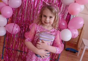 Dziewczynka prezentuje swój upominek podczas przedszkolnego Dnia Kobiet