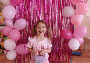 Dziewczynka prezentuje swój upominek podczas przedszkolnego Dnia Kobiet