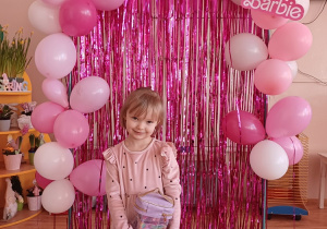 Dziewczynka prezentuje swój upominek podczas przedszkolnego Dnia Kobiet