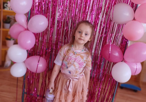 Dziewczynka prezentuje swój upominek podczas przedszkolnego Dnia Kobiet