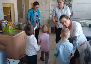 Chłopcy obdarowują panie z przedszkola kwiatami z okazji Dnia Kobiet