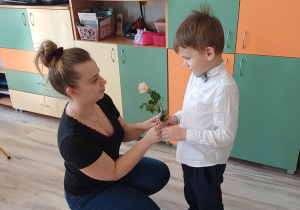 Chłopcy obdarowują panie z przedszkola kwiatami z okazji Dnia Kobiet