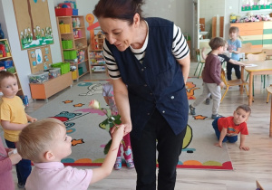 Chłopcy obdarowują panie z przedszkola kwiatami z okazji Dnia Kobiet