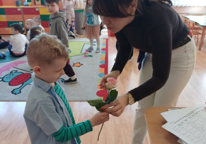 Chłopcy obdarowują panie z przedszkola kwiatami z okazji Dnia Kobiet