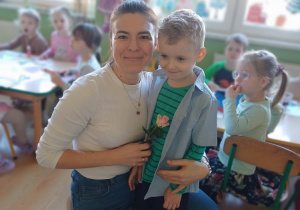 Chłopcy obdarowują panie z przedszkola kwiatami z okazji Dnia Kobiet