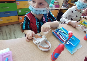 dzieci podczas warsztatów edukacyjnych uczą się jak prawidłowo korzystać z nici dentystycznej