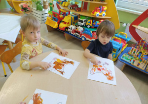 Dzieci kolorują farbami rysunek - kura