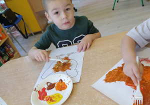 Dzieci kolorują farbami rysunek - kura