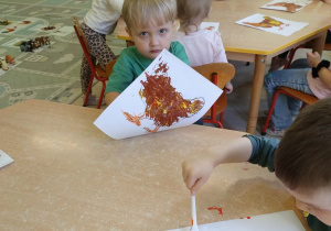 Dzieci kolorują farbami rysunek - kura