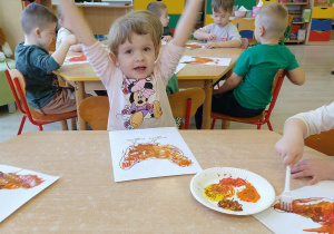 Dzieci kolorują farbami rysunek - kura