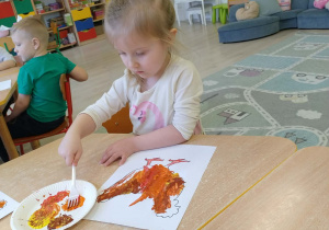 Dzieci kolorują farbami rysunek - kura