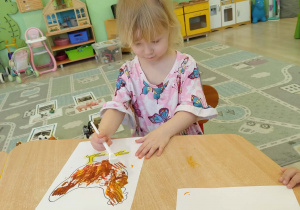 Dzieci kolorują farbami rysunek - kura