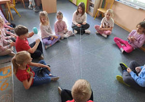 Dzieci przeprowadzają ćwiczenie tworząc sieć z wełny