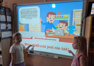 Dzieci wskazują zasady bezpieczeństwa w sieci na tablicy multimedialnej