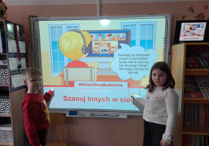Dzieci wskazują zasady bezpieczeństwa w sieci na tablicy multimedialnej