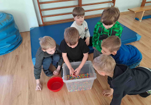 Ćwiczenia z wykorzystaniem zmysłu dotyku - szukanie drobnych elementów w materiale sypkim