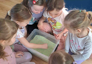 Ćwiczenia z wykorzystaniem zmysłu dotyku - szukanie drobnych elementów w materiale sypkim