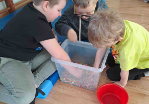 Ćwiczenia z wykorzystaniem zmysłu dotyku - szukanie drobnych elementów w materiale sypkim