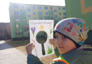 Chłopiec podczas spaceru obserwuje i poszukuje oznak wiosny