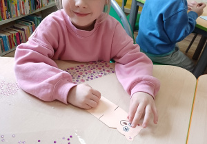 Dziewczynka wykonuje zakładkę do książki