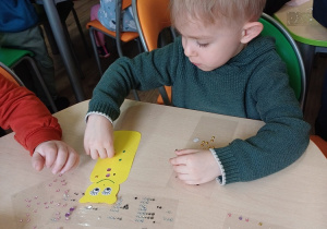 Chłopiec wykonuje zakładkę do książki