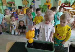 Dziewczynka podlewa nasiona