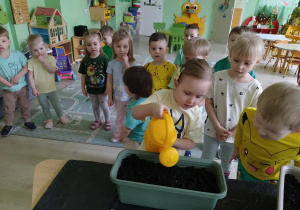 Dziewczynka podlewa nasiona