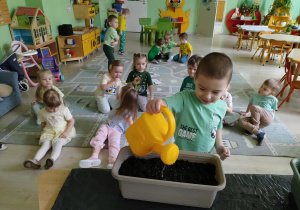 Chłopiec podlewa nasiona
