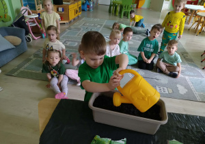 Chłopiec podlewa nasiona