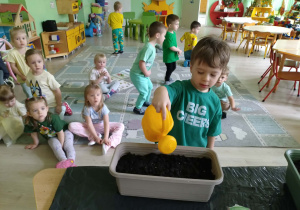 Chłopiec podlewa nasiona