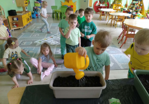 Chłopiec podlewa nasiona