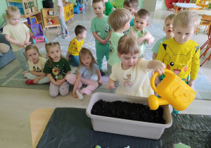 Dziewczynka podlewa nasiona