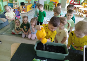 Chłopiec podlewa nasiona