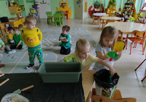 Dziewczynki wsypują ziemię do doniczki