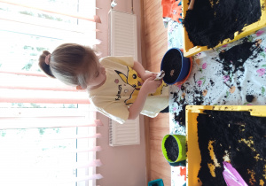 Dzieci podczas zajęć ogrodniczych wysiewają nasionka