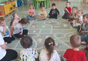 Dzieci siedzą w kole i słuchają pani dietetyk