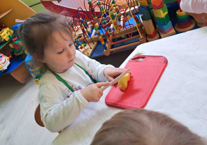 Dzieci kroją przygotowane owoce