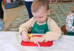 Dzieci kroją przygotowane owoce